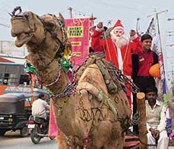 A man dressed as Santa rides a camel cart in Mathura on Saturday. 