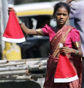 A girl sells Santa Claus caps on a road in Mumbai on Sunday. As per the market estimates, the world market of Christmas festive products is nearly $10 billion. China, Hong Kong, Germany, USA, Netherlands, Thailand, Taiwan, Poland, Canada and the UK are the top 10 exporters of the festive products while exports from India are also on the rise. 