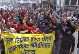 Members of the Navniukat Rural Health Pharmacist Association agitate to press for the acceptance of their demands in Jalandhar on Sunday