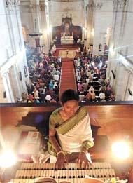 A devotee plays the piano at the midnight Mass on Christmas at Cathedrel Church of Redemption.  