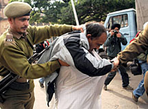 Policemen detain a protester who protested against the shifting of the artifacts from the old palace complex to the Secretariat in Jammu on Monday.
