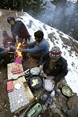 Beating the chill: Locals warm themselves while a vendor prepares an omelette in Patnitop on Wednesday.