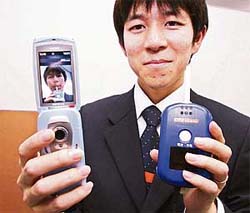 Japan's second largest mobile operator KDDI engineer Munezumi Wada displays alcohol tester