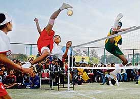 A Manipur player kicks a smash while an Andhra player tries to hit back during the 10th Junior National Sepak Takraw Championship at the St Josephs Sector 44 grounds in Chandigarh