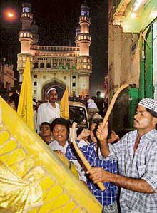 A man beats a drum during the historic procession of Dargah Yousfian in Hyderabad. 
