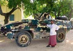 A Somalian stands next to an armoured vehicle in Mogadishu