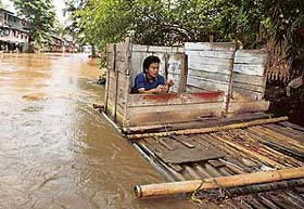 A resident uses a floating public toilet on the Ciliwung river bank in Jakarta on Thursday.Government and aid agencies were moving food, water and medical supplies to persons forced into temporary shelters by floods and landslides.