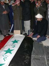 Iraqis grieve at the grave of Saddam Hussein in his home village of Awjah on Sunday