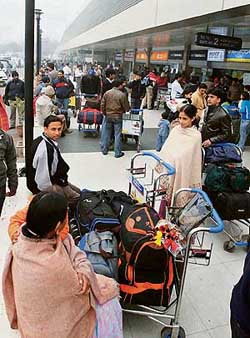 Passengers stranded at the IGI Airport after flights were delayed on Monday due to heavy fog in New Delhi