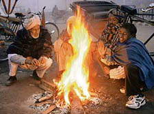 Labourers warm themselves around a bonfire to fight chill in Bathinda on Tuesday.