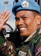 A Malaysian soldier waves to photographers after his arrival at the Beirut airport on Tuesday.