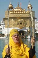 A devotee holds swords and shouts slogans during a procession on the eve of birth anniversary of Guru Gobind Singh in Amritsar on Thursday.