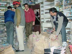 Police personnel conficate pirated CDs from a shop in the Phagwara Gate market in Jalandhar