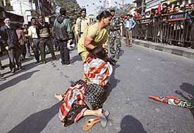 A polcewoman detains an activist from the Trinamul Congress in Siliguri during state-wide bandh in Bengal on Monday.