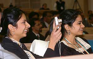 Delegates take photographs and enjoy the proceedings at the plenary session of the Pravasi Bharatiya Divas in New Delhi on Monday. 