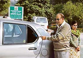 The car owner points at the broken windowpane of his car from which cash was stolen