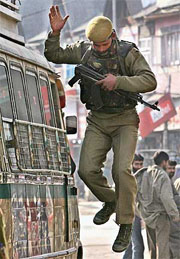 A CRPF jawan jumps from a private bus after checking the luggage of passengers on the roof of a bus in Srinagar on Tuesday.