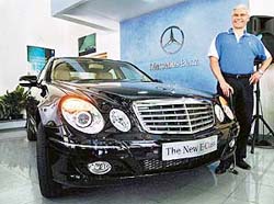 CEO & Managing Director DaimlerChrysler India Wilfred Aulbur poses with newly launched Mercedes E Class car at a press conference in Bangalore 