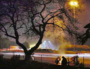 As evening draws, migrants sit around a bonfire to beat the cold in Chandigarh.