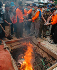 Officials and residents burn the carcasses and cages of culled poultry in a residential area in Jakarta on Monday.
