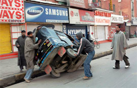 Youths overturn an autorickshaw during a strike in Srinagar on Wednesday.