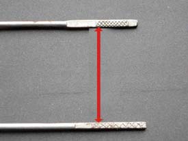 The arrow indicates the unequal markings on the dipsticks