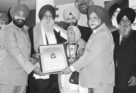 NRI Raghbir Singh Bains (second from left) being honoured for social service in Ludhiana recently