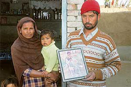 Raghbir Singh with a photograph of landmine victim Balwinder Singh at Naushara Dhalla in Tarn Taran on Monday.