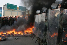 Lebanese soldiers stand guard in front of protesters burning tyres in Dora, east of Beirut on Tuesday.