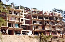 A multi-storey commercial complex being illegally constructed in gross violation of land use on a reserve forest land at a prime location in McLeodganj