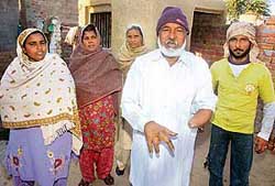 Sujjan Singh with an amputated hand along with his family at Naushera Dhalla village in Tarn Taran 