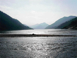 The cloud-laced hill range is breath-taking as the boat negotiates through the serpentine river.