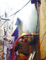 A fireman trying to control fire in a godown in Chandni Chowk area in the Capital on Sunday.