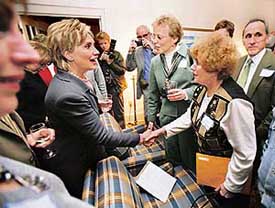 US presidential hopeful Senator Hillary Clinton (left) shakes hands with supporters during a house party in Cedar Rapids, Iowa, on Saturday.