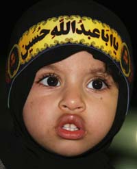Ten-year-old Najla, wearing a headband which reads Our Father Hussein, offers prayers during Ashura in the Shia town of Qatif on Tuesday. 