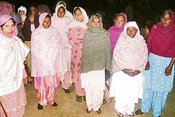 Women prepare to check the entry of supporters of candidates who had been supplying liquor and poppy husk to woo voters in Bhaini Baringa village near Ahmedgarh