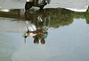 A scooterist drives on the water-logged road near the Government Multispeciality Hospital, Sector 16, Chandigarh, on Wednesday.