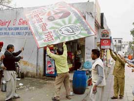 Municipal Corporation employees remove an election hoarding in Mohali on Friday.