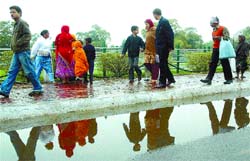 People take a stroll on the sidewalk at India Gate