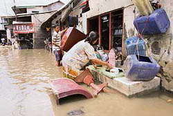 Residents wash their utensils at a flooded slum area in east Jakarta on Saturday. Thousands of Indonesians were cleaning up mud and debris from their flood-damaged homes after rains eased and waters that forced many into cramped emergency shelters began to subside.  Reuters
