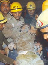 An injured man being carried by police personnel after a building collapsed at Madipur in the Capital on Sunday