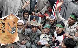 Protesters hold photographs of missing youths as they shout slogans at a rally in Srinagar on Monday. 
