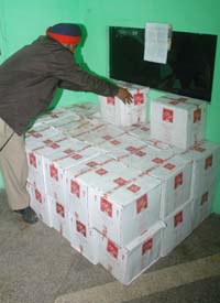 A policeman counts the cases of liquor that were seized from a house in Jalandhar