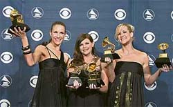 Band members of Dixie Chicks, Martie Maguire (L), Natalie Maines (M), and Emily Robison (R) pose with their trophies at the 49th Grammy Awards 