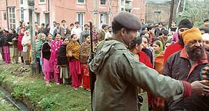 A security man stands guard at a polling booth as voters queue up to exercise their right to franchise in Ludhiana on Tuesday.