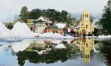 A scene of the Ridge in Shimla, with a reflection of historical Chirst Church seen in melting snow, on Wednesday.