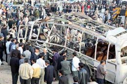 People gather around the remains of a bus following an explosion targeting Iran's elite Revolutionary Guards in Zahedan, south east of Iran, on Wednesday. 