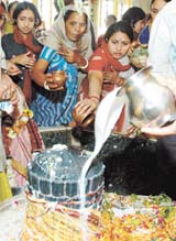 Devotees pouring milk on Shivaling on the