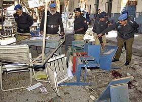 Policemen inspect the blast site in Quetta where at least 16 persons were killed and around 24 injured when a powerful bomb exploded in a court