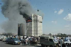 Fire fighters try to control a fire at the Pakistan National Shipping Corporation building in Karachi on Sunday. A Pakistan Navy helicopter evacuated five persons from the building.